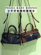 Denim Prada bag with double top handles, front triangle logo, and contrast stitching