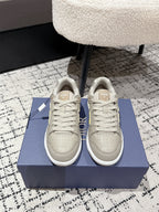 Beige Dior low-top sneakers with yellow logo, lace-up front view
