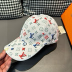 White baseball cap with multicolor monogram print and curved brim, side view.