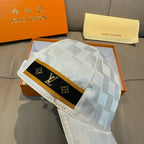 Louis Vuitton cap front panel: black monogram band with gold trim on gray-blue check