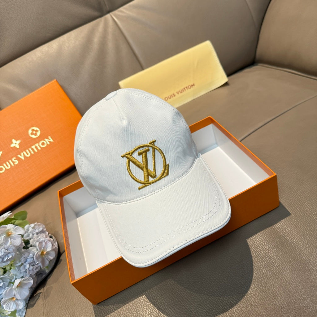 White baseball cap with gold Louis Vuitton-style monogram on the front panel