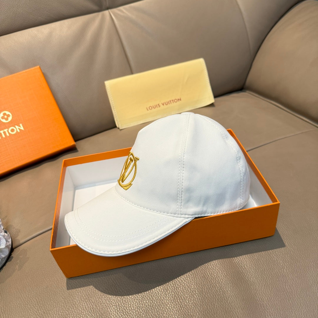 Light blue baseball cap with gold monogram logo on the front, curved brim