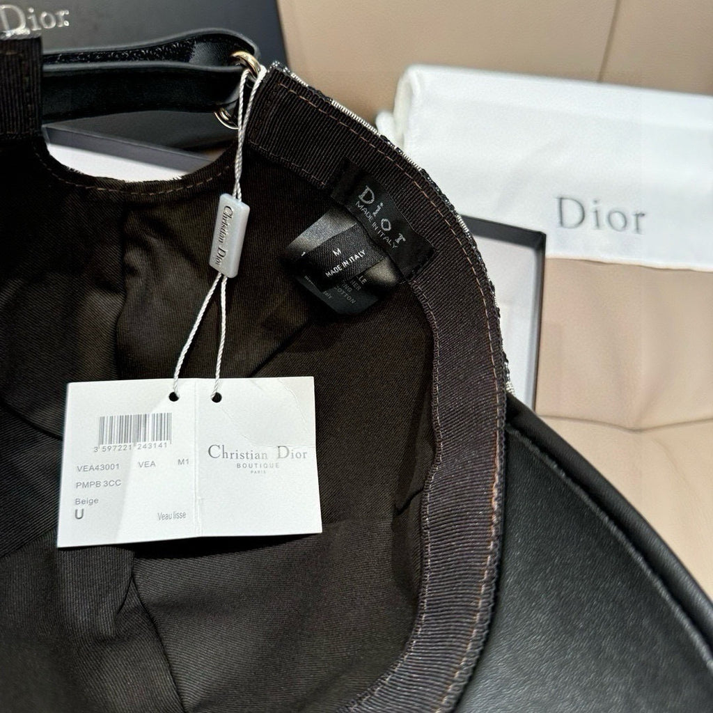 Dior cap with hanging product tags on black fabric and black leather brim