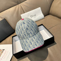 Light blue monogram baseball cap with pink top button and pink-trim brim edge