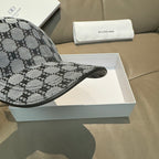 Balenciaga cap brim close-up in gray and black monogram fabric with stitched edge.