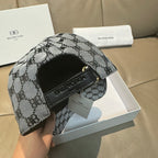 Balenciaga cap side view with gray-and-black monogram fabric and black strap detail.