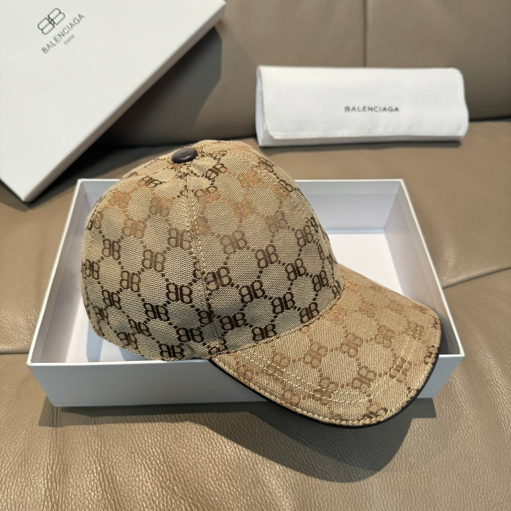 Tan monogram baseball cap with curved brim, textured fabric, and stitched paneling.