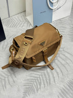 Tan shoulder bag with flap and buckle strap, gold hardware, angled view