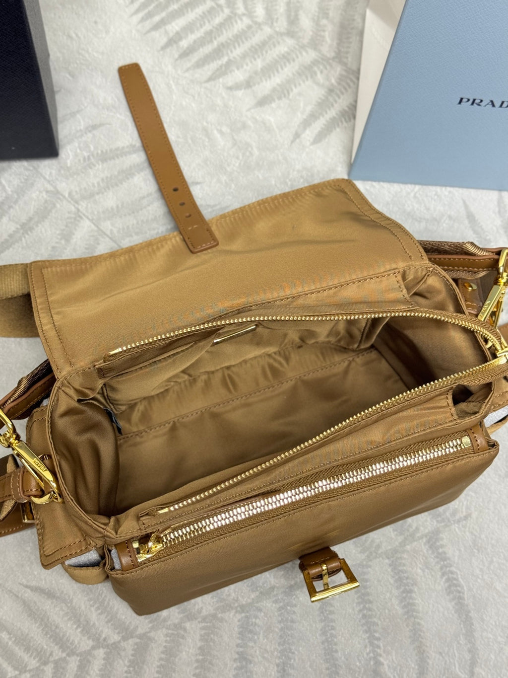 Tan handbag with open front pocket and gold zipper trim, interior view