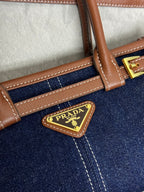 Prada denim and leather top handle strap with Prada logo plate and gold buckle hardware