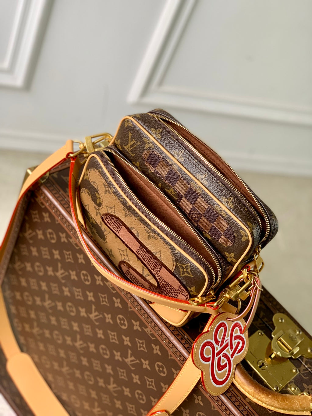 Louis Vuitton monogram canvas mini bag with orange strap, zipper detail and logo charm