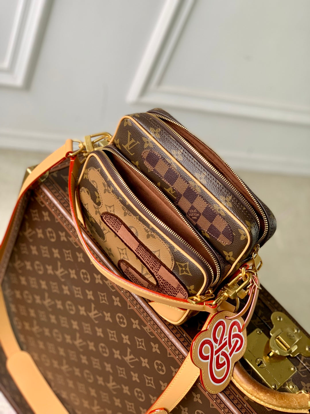 Louis Vuitton monogram canvas mini bag with orange strap, zipper detail and logo charm