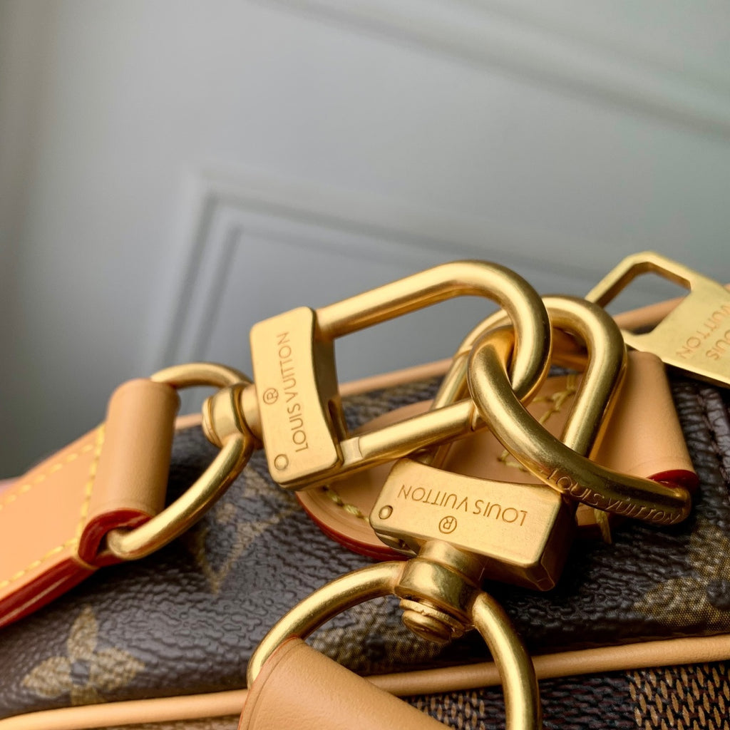 Louis Vuitton bag hardware close-up with gold clasp and tan strap across monogram canvas