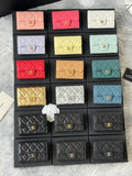 Small quilted flap wallet bags set in pink, red, white, yellow, teal, and black with logos.
