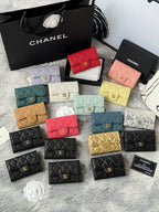 Small quilted flap wallet bags assortment in red, white, peach, yellow, teal, and black.