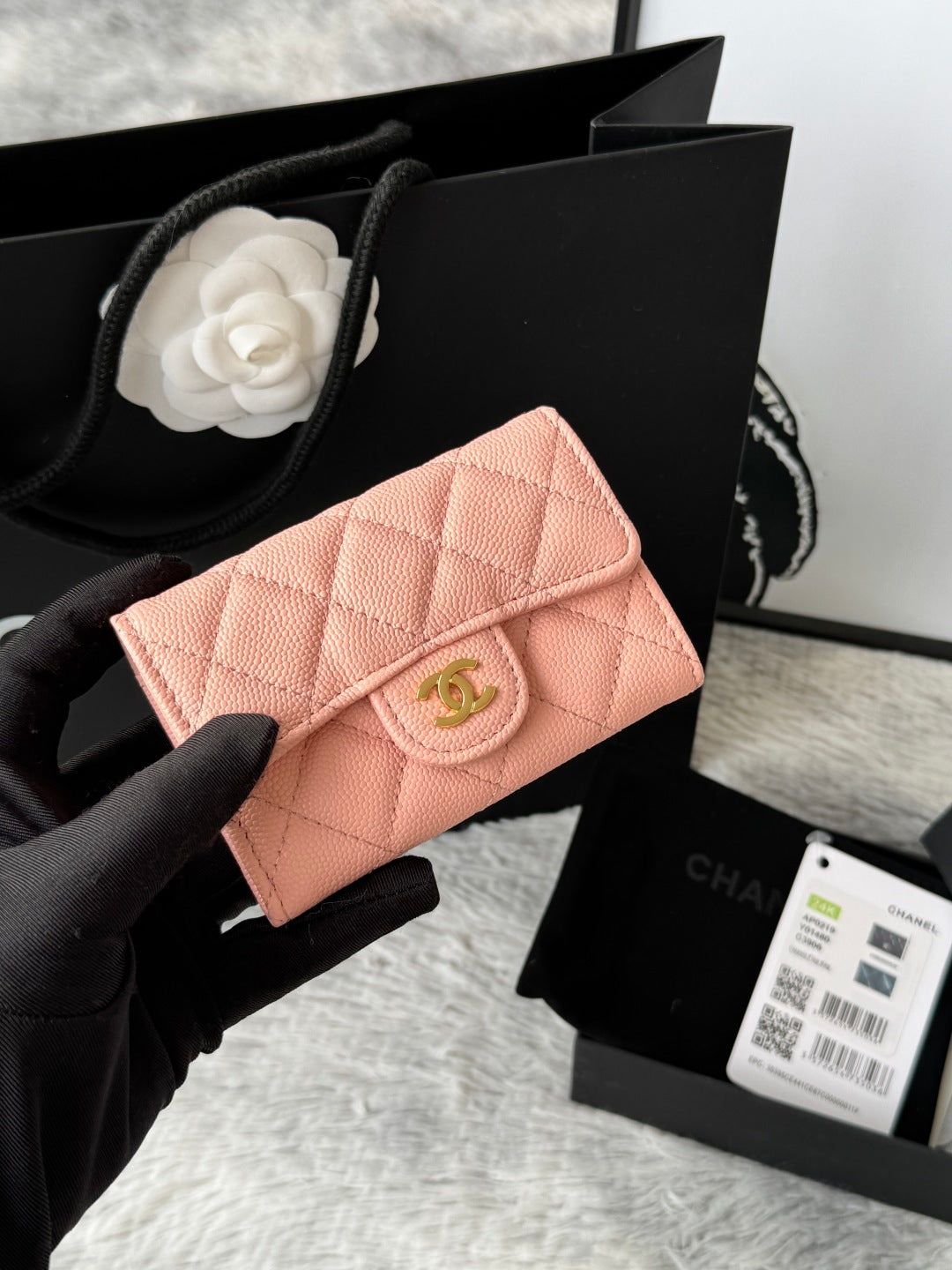 Quilted flap bag with gold logo, blush pink textured leather, magnetic snap closure.