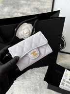 Quilted flap bag with gold logo, light gray textured leather, magnetic snap closure.