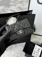 Quilted flap bag with gold logo, dark gray textured leather, magnetic snap closure.