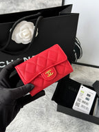 Quilted flap bag with gold logo, red textured leather, magnetic snap closure.