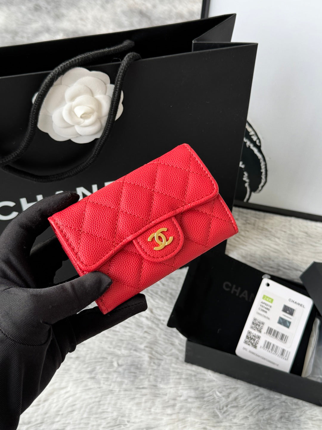 Quilted flap bag with gold logo, red textured leather, magnetic snap closure.