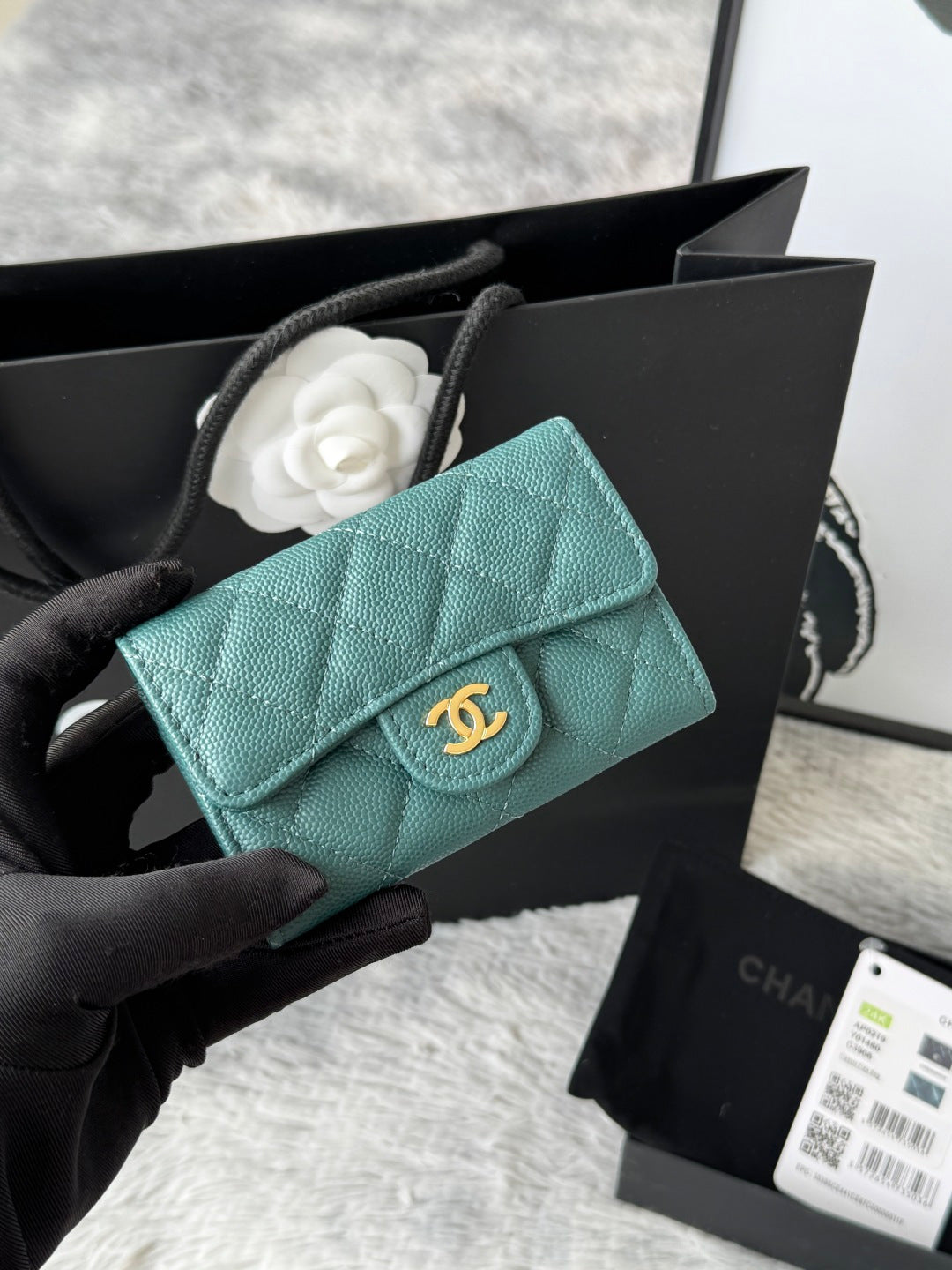 Quilted flap bag with gold logo, turquoise textured leather, magnetic snap closure.