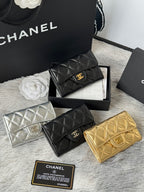 Quilted mini flap bags in black, silver, and gold with logo emblem