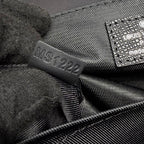 Bag interior tag and woven label reading “MUST1222” on dark lining.