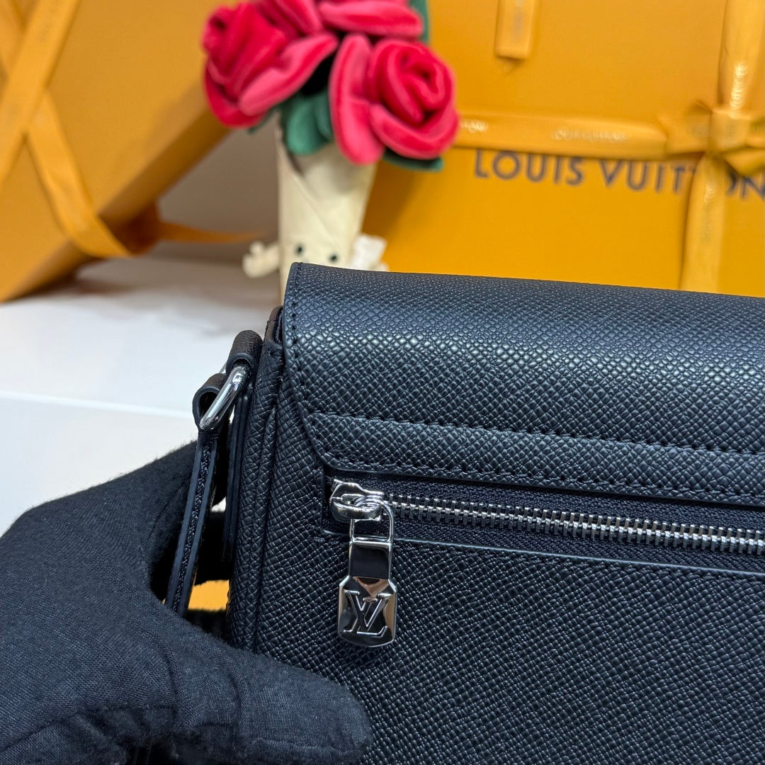 Louis Vuitton dark blue textured bag with front zipper pocket and metal pull charm.