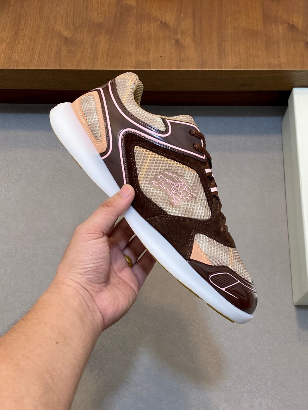 Burberry lace-up sneaker held by the heel, brown and beige upper with white sole