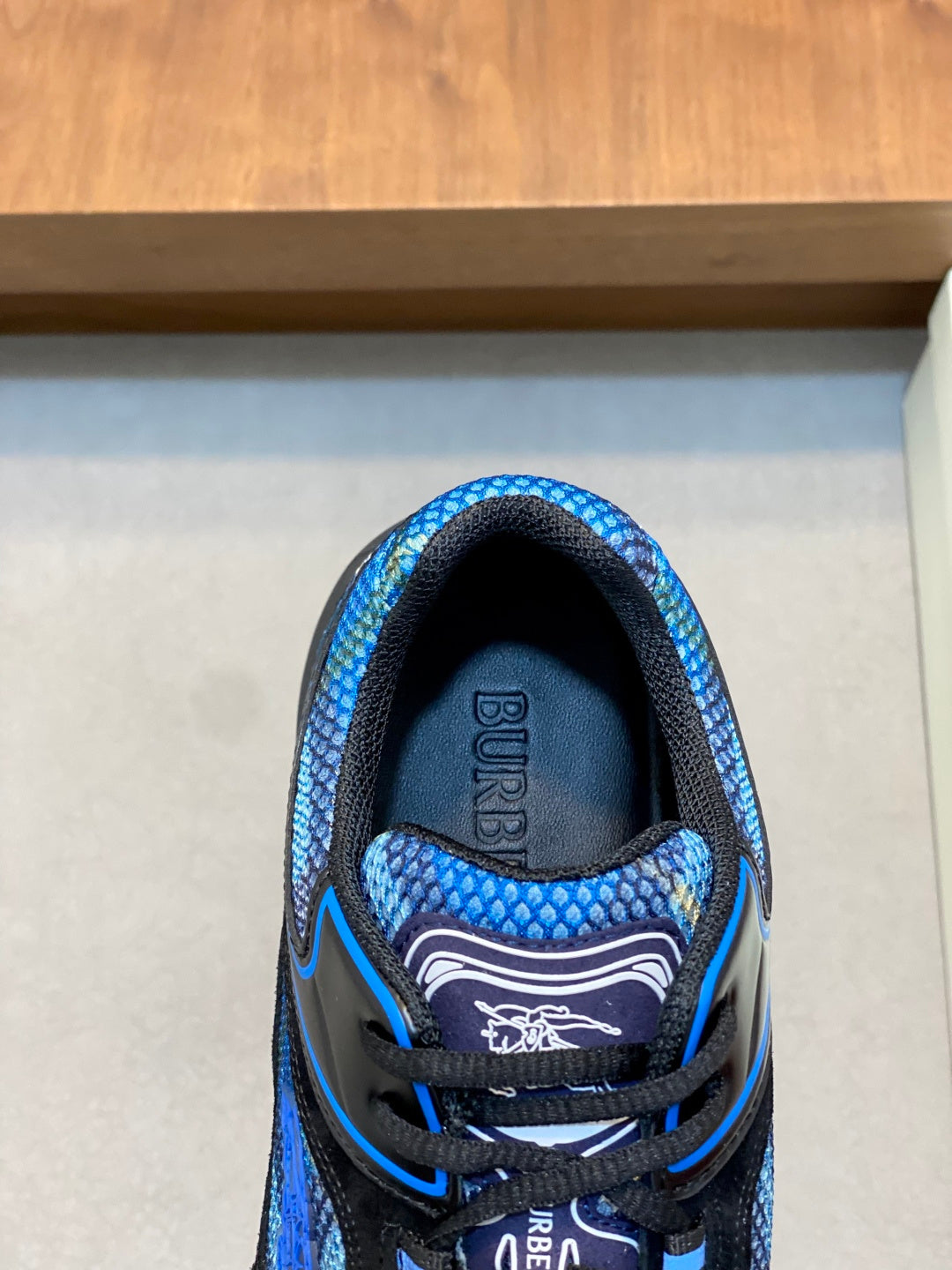 Close-up of blue and black sneaker tongue and lace area, Burberry