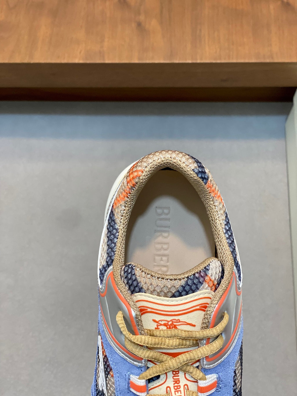 Burberry sneakers close-up of tongue and collar, blue fabric with orange trim