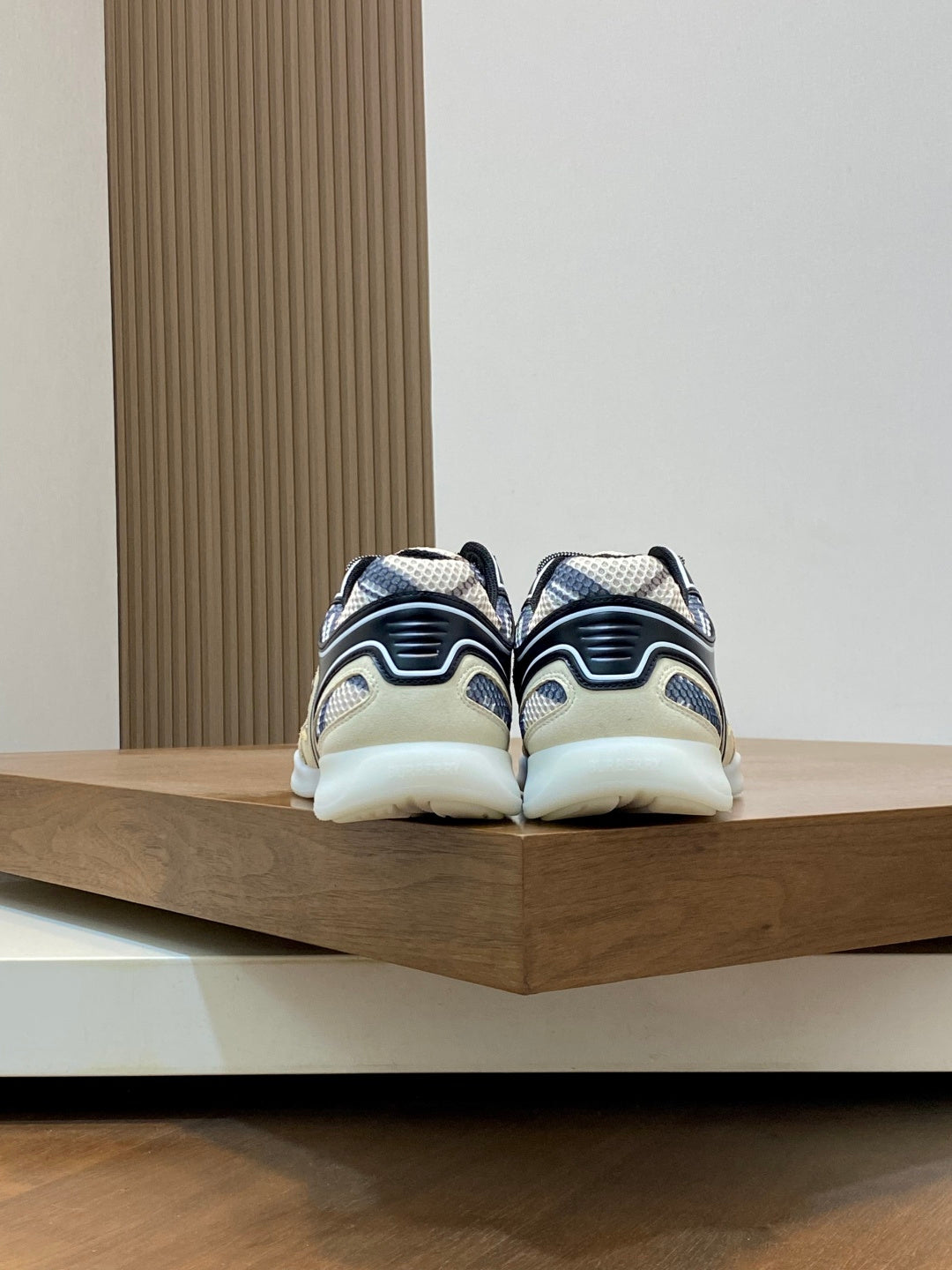 Back view sneakers, beige and navy patterned uppers, white heel with black outline