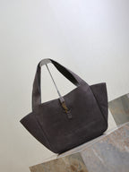 Dark gray suede tote bag angled view, short handles and YSL logo charm