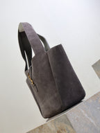 Dark gray suede tote bag with side profile and hanging YSL logo charm