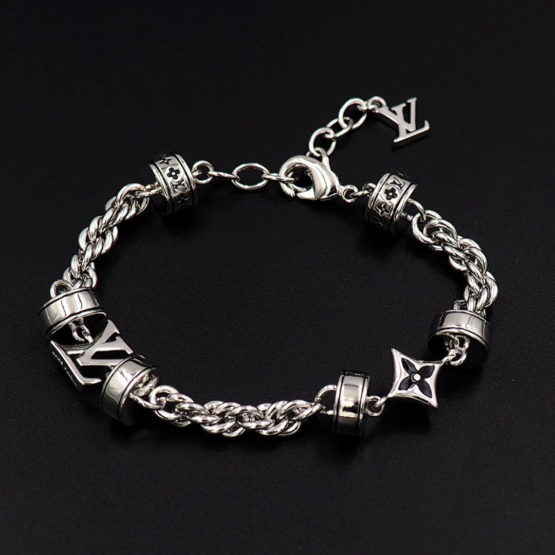 Louis Vuitton charm bracelet closeup, silver linked chain with logo blocks and star charms