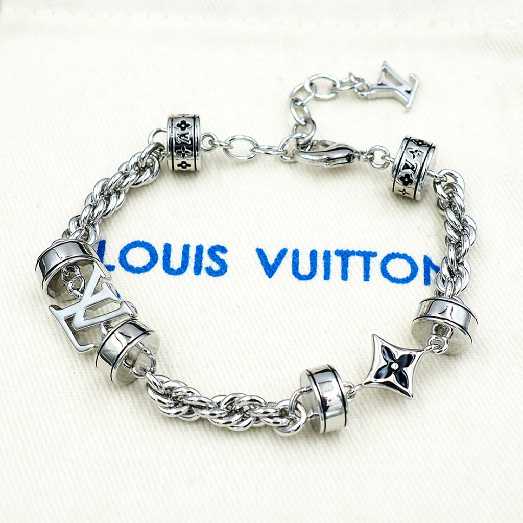 Silver chain bracelet with barrel charms and star pendant details