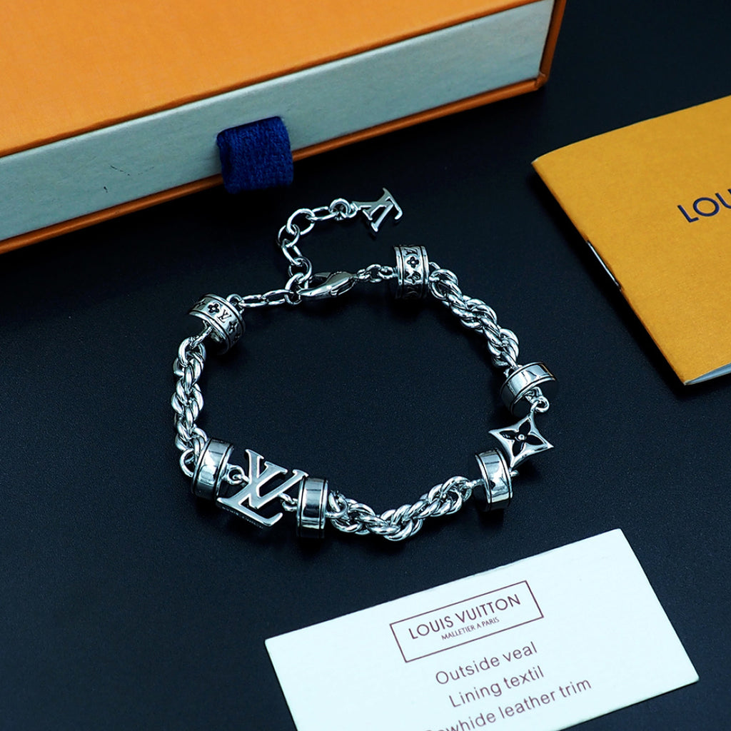 Louis Vuitton charm bracelet, silver linked chain with logo blocks and star charms