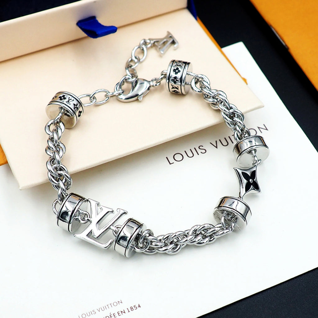 Louis Vuitton charm bracelet closeup, silver linked chain with logo beads and star charm