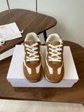 Brown and white sneakers with white laces, pair on white shoebox
