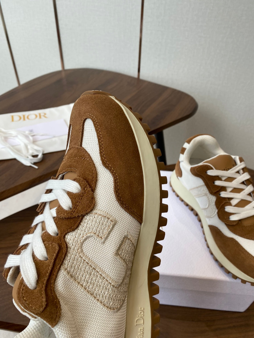 Brown and white sneakers with white laces, side and heel view on shoebox