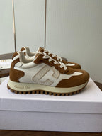Brown and white Dior sneakers with white laces, side view on white shoebox