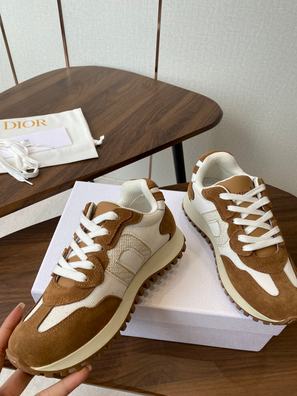 Brown and white lace-up sneakers with white laces on white shoebox