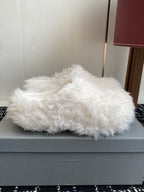 White faux-fur slide sandals on a light-gray box, open toe and low profile