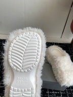White faux-fur sandals with textured rubber outsole and molded tread pattern