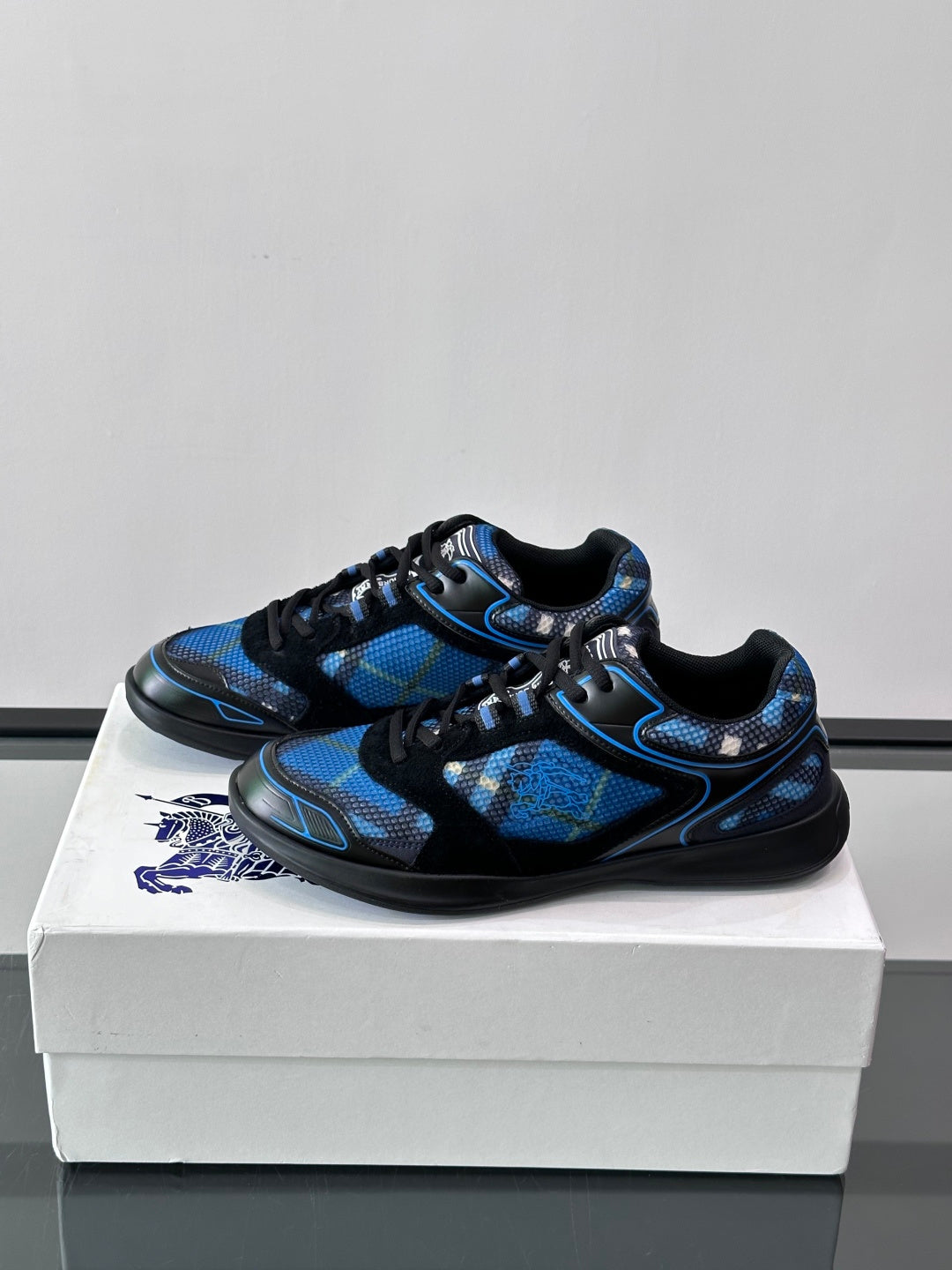 Blue and black lace-up sneakers with textured pattern and cushioned toe caps
