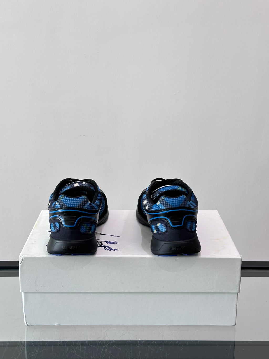 Back view of blue and black sneakers with lace-up details and heel branding