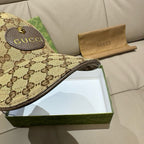 Gucci GG monogram cap brim close-up in beige with dark logo pattern and stitched logo patch.