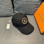 Louis Vuitton baseball cap in dark black with yellow LV logo patch and hanging tag.