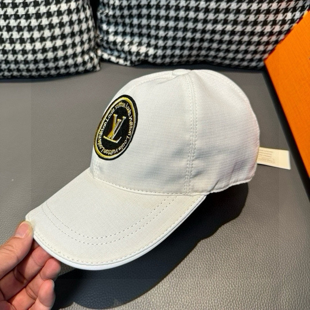 Louis Vuitton white baseball cap close-up with round LV logo patch on front