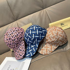 Set of three Burberry logo caps in blue, pink, and tan repeating monogram patterns